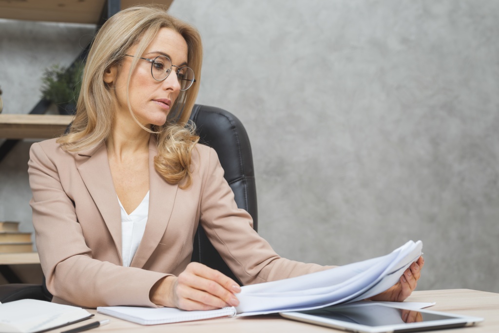 blonde-young-businesswoman-reading-documents-workplace.jpg сотрудник